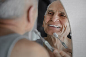 Man Looking at The Mirror Wearing Dentures
