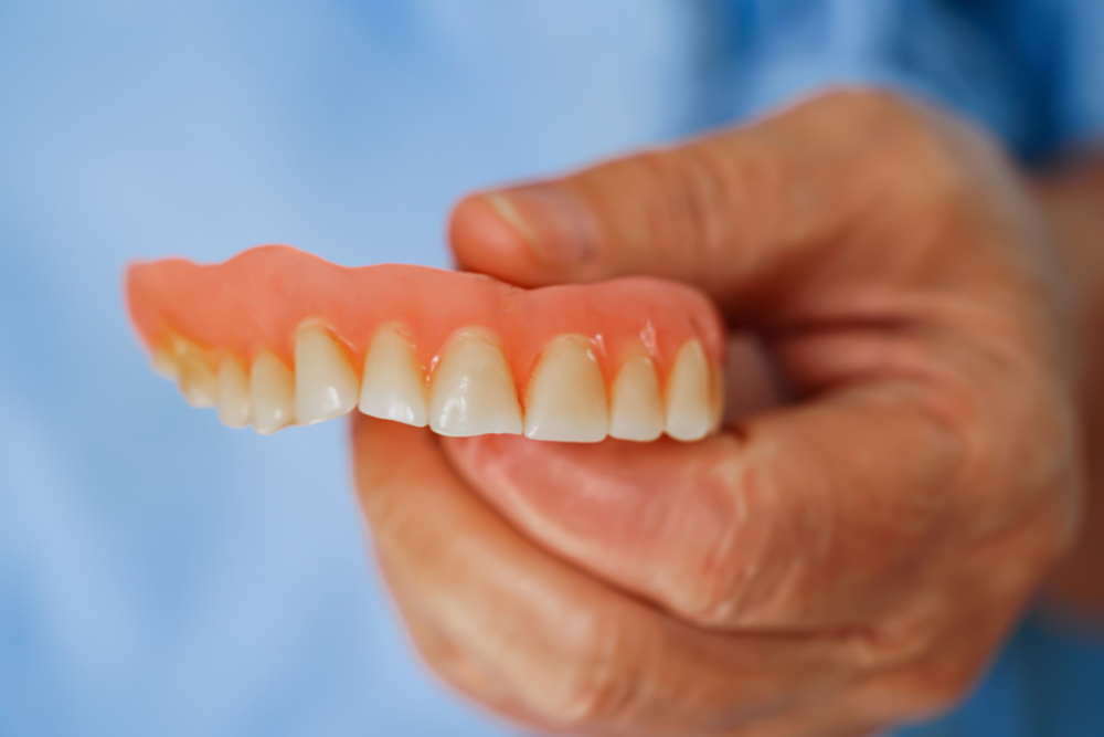 Closer Look Of Holding A Denture